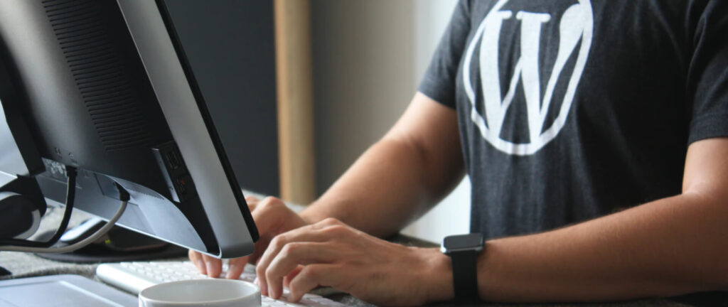 Man achter computer met Wordpress shirt