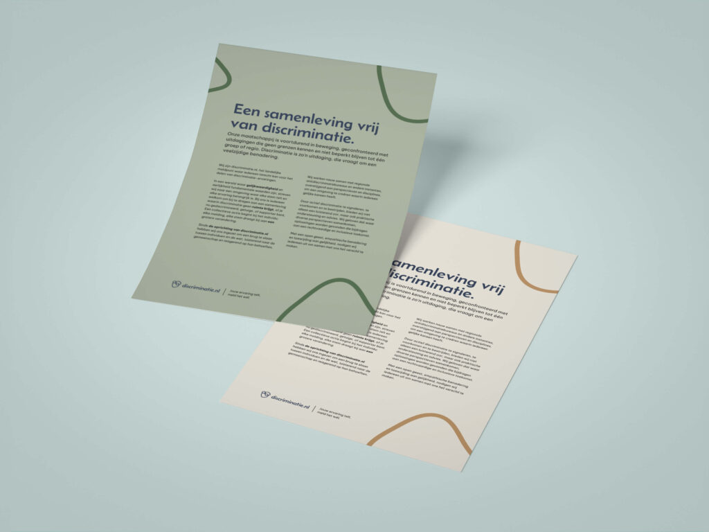 Twee gevouwen folders van Discriminatie.nl die schuin op een tafel liggen. De titels op de folders luiden: "Een samenleving vrij van discriminatie."