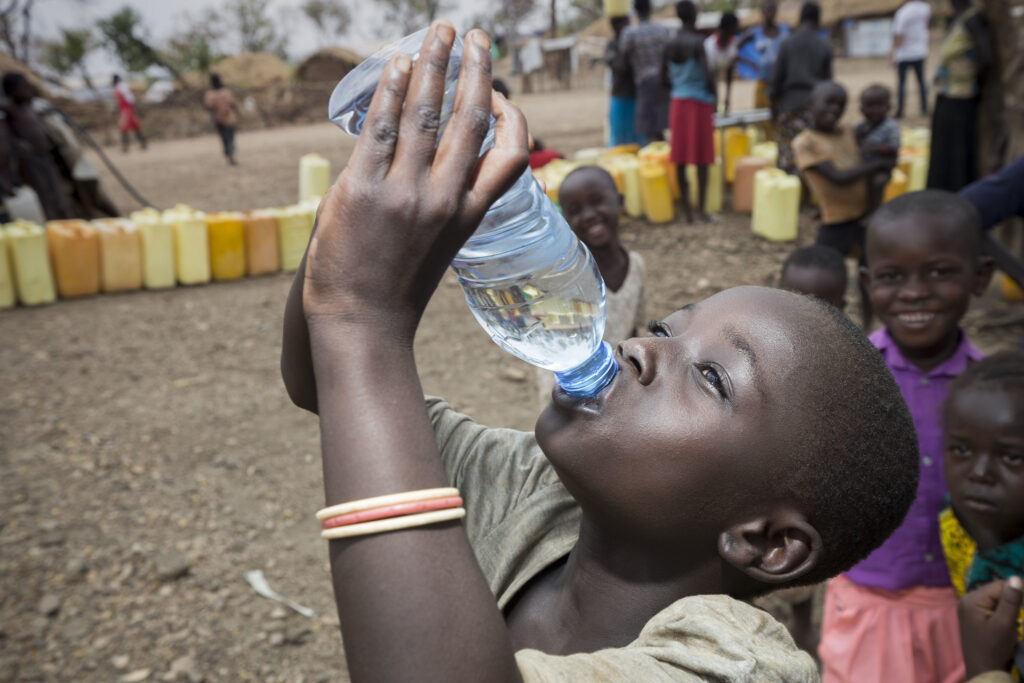 Een meisje drinkt water in een vluchtelingenkamp in zuid soedan.