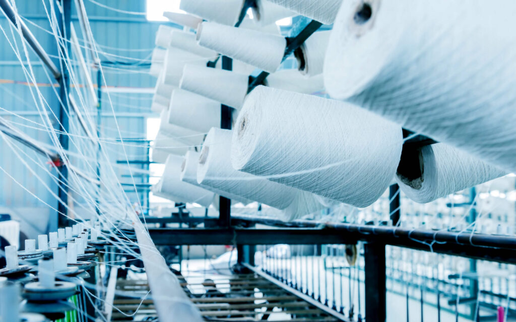 Close-up van vele grote witte klossen garen in een textielfabriek.