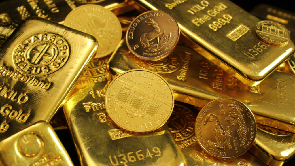 Een close-up van een stapel gouden baren en verschillende gouden munten.